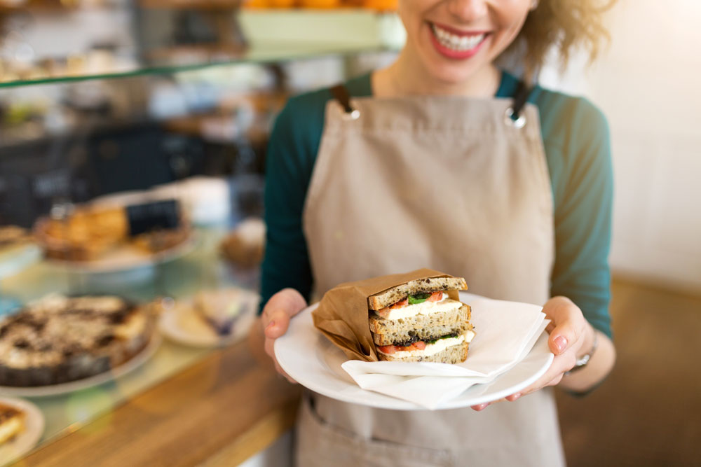 AdobeStock_260522701_ woman serving sandwhich