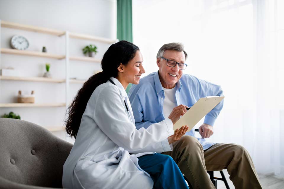 happy doctor with patient looking at documents